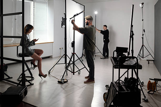 Backstage process of production crew setting up lights and equipment preparing for filming video shoot copy space
