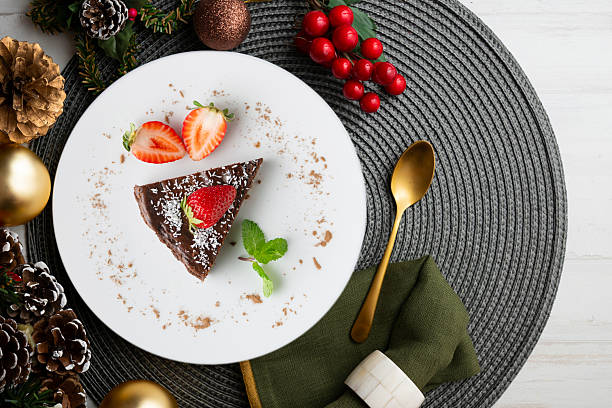 istock Chocolate cheesecake with fresh strawberries. Top view table with christmas decorations. 2212344135