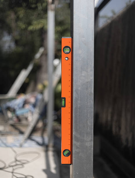 istock Construction worker use spirit level and measures the vertical of the iron pole in site. 2212344936