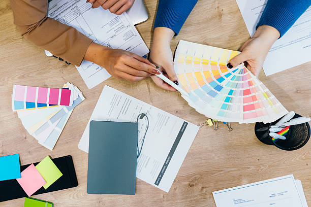 istock Lose up of female hands on office table with papers and color samples. 2212345381