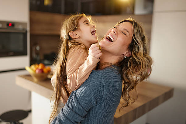 istock Cheerful mother having fun with her daughter at home. 2212346592
