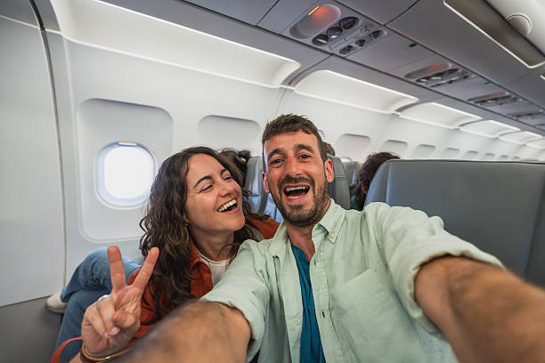 istock Happy couple taking selfie on airplane before vacation trip 2212346686