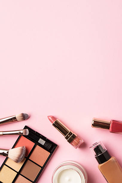 istock Cosmetic palette, brushes, cream and lipstick. Flat lay image with copy space on pink background. 2212347070