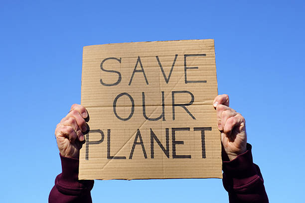 istock Activist holding sign calling to save our planet during demonstration 2212347079