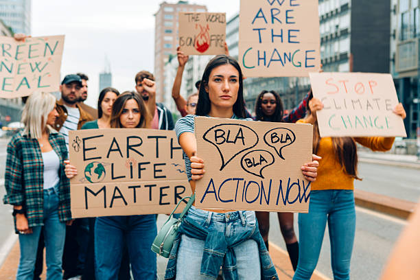 istock Activists protesting against climate change holding protest signs demanding action 2212347753