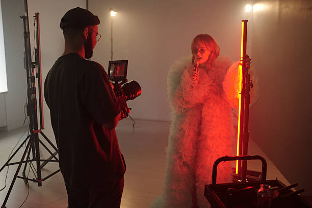 istock Director Filming Woman Singing Into Microphone during Video Shoot 2212348749