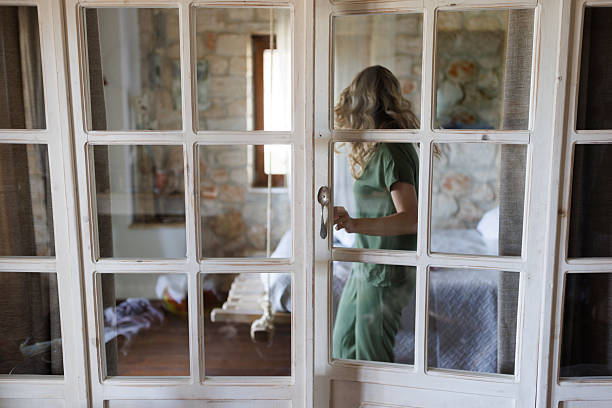Little girl looking from the open window of country house