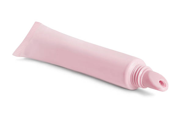 Blank pastel pink lip balm tube lying on white background