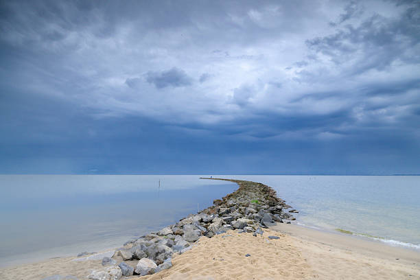Storm clouds over a dam in the IJsselmeer during a springtime day along the IJsselmeer lakeshore.