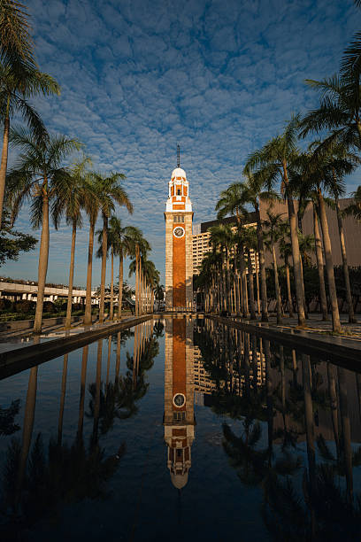 Clock Tower reflected in pool with palm trees, Tsim Sha Tsui, Hong Kong
