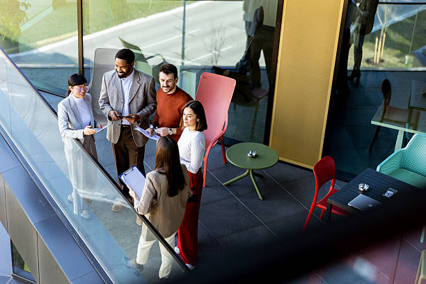 istock Group of professionals collaborating on project details in modern office space during sunny day 2212355434