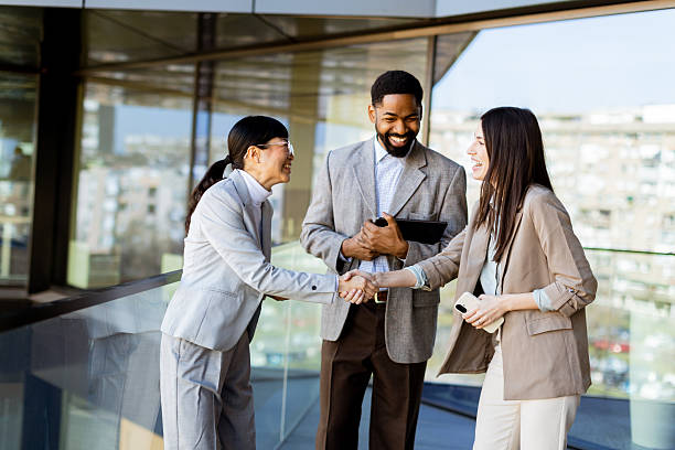 istock Business professionals engage in a friendly handshake on a sunny day in a modern office building 2212355436