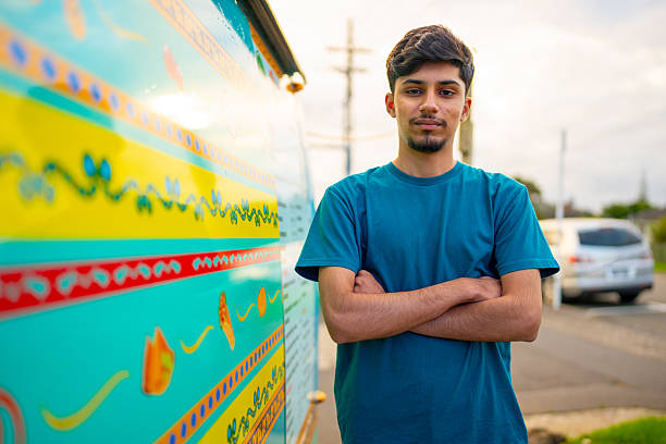 Confident Young Entrepreneur Standing Beside Colorful Vehicle