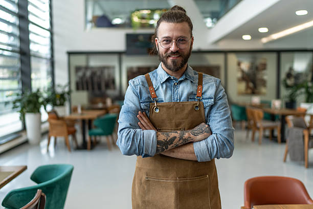 istock Confident barista standing with arms crossed in his cafe 2212363849