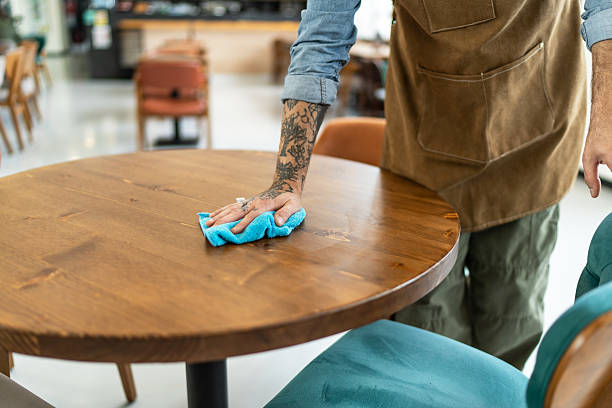 istock Waiter cleaning table with blue cloth in restaurant 2212365501