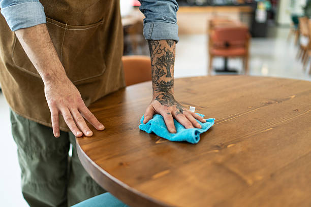 istock Waiter cleaning and disinfecting tables in a restaurant 2212365511