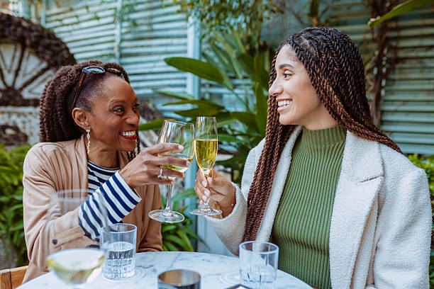 istock Two cheerful black women toasting with white wine in a restaurant 2212365842