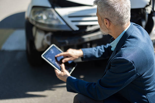 istock Representative from the insurance company assessing accident damage on-site 2212365932