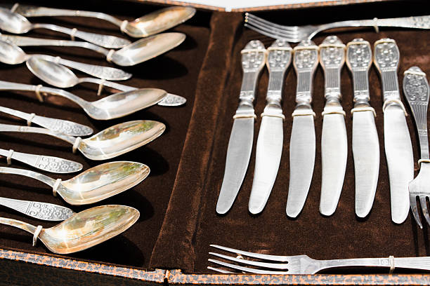 istock Antique silver cutlery set arranged neatly in a decorative case with intricate designs 2212367580