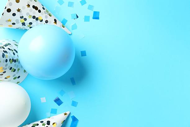 istock Party hats, air balloons and confetti on light blue background, flat lay. Space for text 2212367679