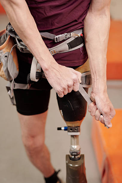 istock Young man with physical disability fixing climbing equipment 2212368799