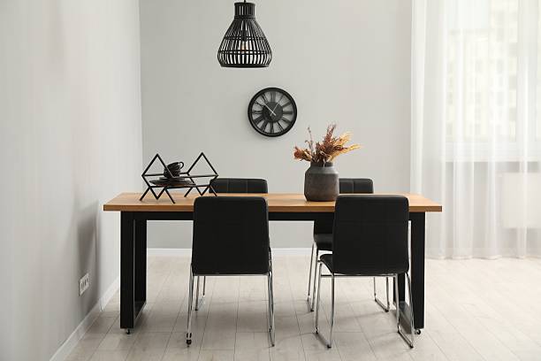 Blank wall clock above the wooden shelf on green wall with copy space.