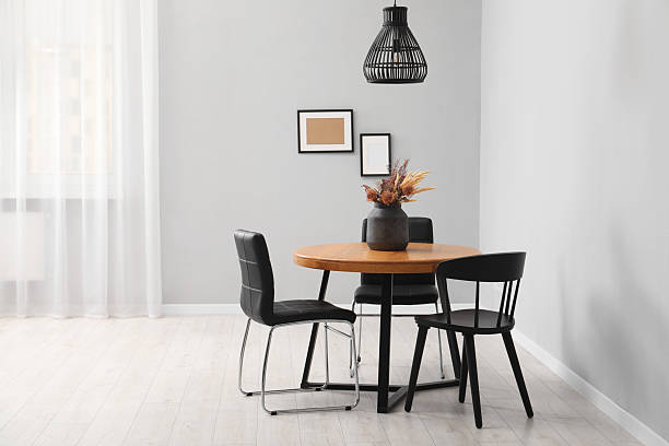 istock Wooden table with black chairs in stylish dining room 2212370444