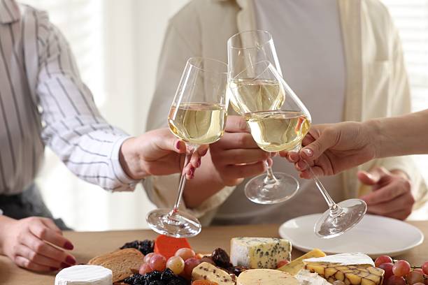 istock People clinking glasses of wine at served table, closeup 2212370920