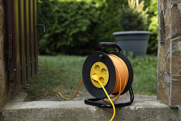 istock Extension cord reel in backyard. Electrician's equipment 2212371927