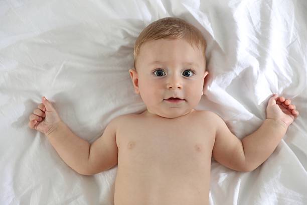 istock Cute little baby on bed at home, top view 2212371934