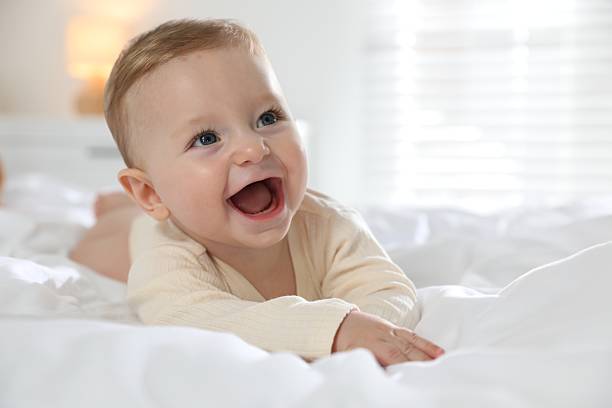 istock Cute little baby on bed at home 2212371951