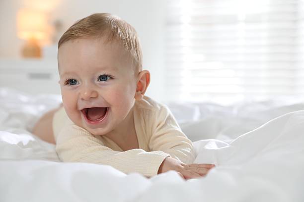istock Cute little baby on bed at home 2212372002
