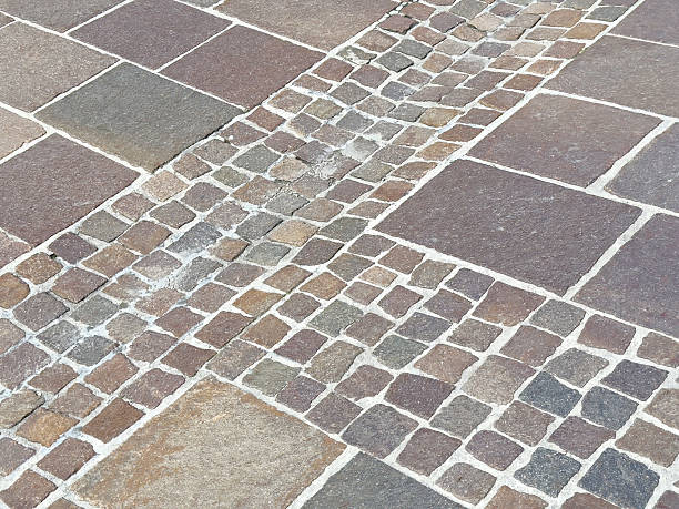 istock Detailed view of a cobblestone pavement with varying tones and patterns 2212372296