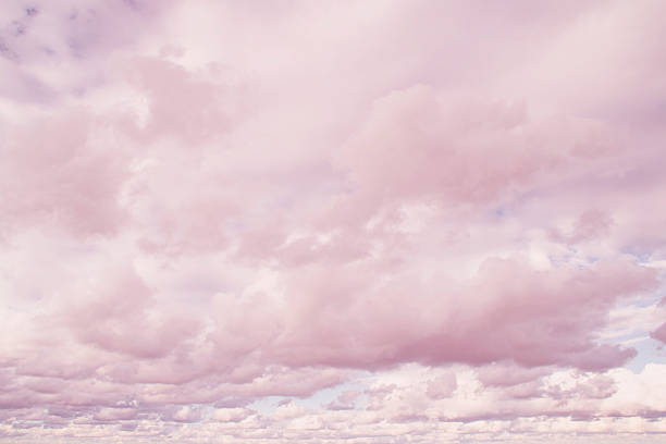 Blue sky with a pink stripe at the horizon. Calm background with evening clouds.