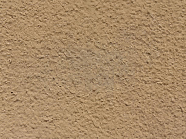 istock Close-up of textured beige concrete wall surface 2212372746