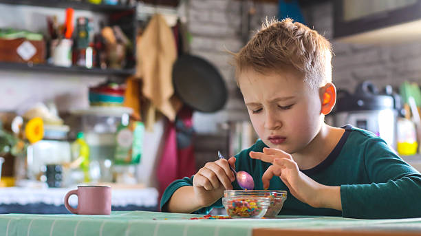 istock boy at the table in the kitchen having breakfast with dry cereal and milk 2212373213
