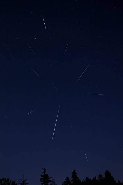 istock Milky Way stars, planets, comets and meteor shower trails and countryside tree silhouettes. 2212373389
