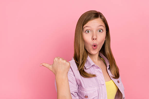 istock Profile side photo of young impressed lady indicate finger empty space promo ads isolated over pink color background 2212374340