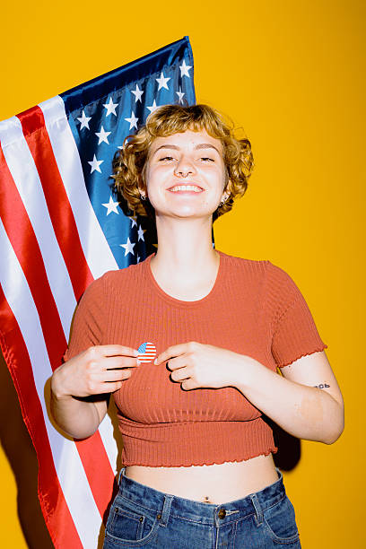 istock Smiling patriot celebrates her pride in front of a vibrant flag 2212374507