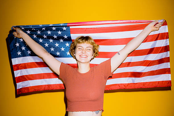 istock Joyful celebration under vibrant yellow backdrop with flag 2212374665