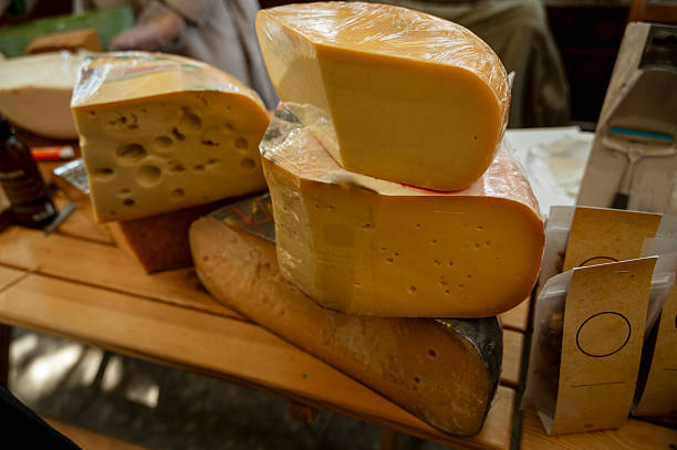 istock Farmer cheese on a market stall, huge wheels of different types of cheese. 2212374863