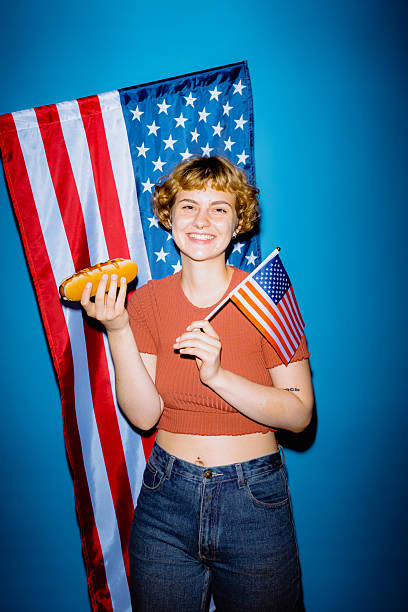 istock Joyful celebration with hot dog and American flag backdrop 2212374915