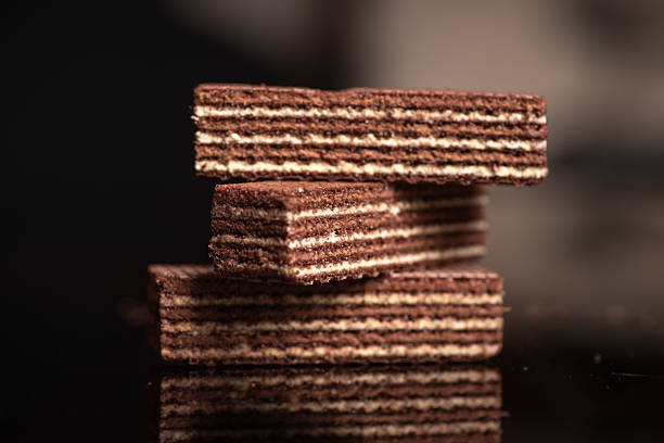 Chocolate wafer biscuits stacked together on reflective surface Chocolate wafer biscuits stacked together on reflective surface