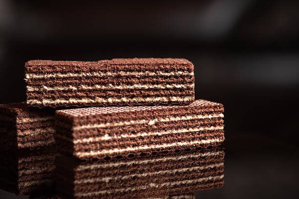 Chocolate wafer biscuits stacked together on reflective surface