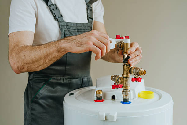 istock Worker wrapping plumbing tape around a fitting on a water heater 2212376269