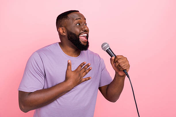 istock Portrait of attractive cheerful guy mc singing hit pop performance isolated over pink pastel color background 2212376319