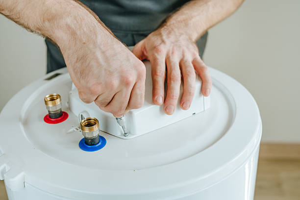 istock Technician's hands using a screwdriver to repair an electric water heater 2212376718