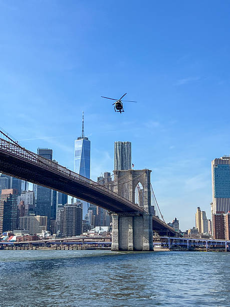 istock Helicopter Flying Over Brooklyn Bridge with NYC Skyline 2212377010