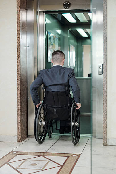 istock Back view of disabled businessman entering elevator 2212378376