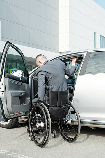 istock Disabled businessman in wheelchair getting into his car 2212378380
